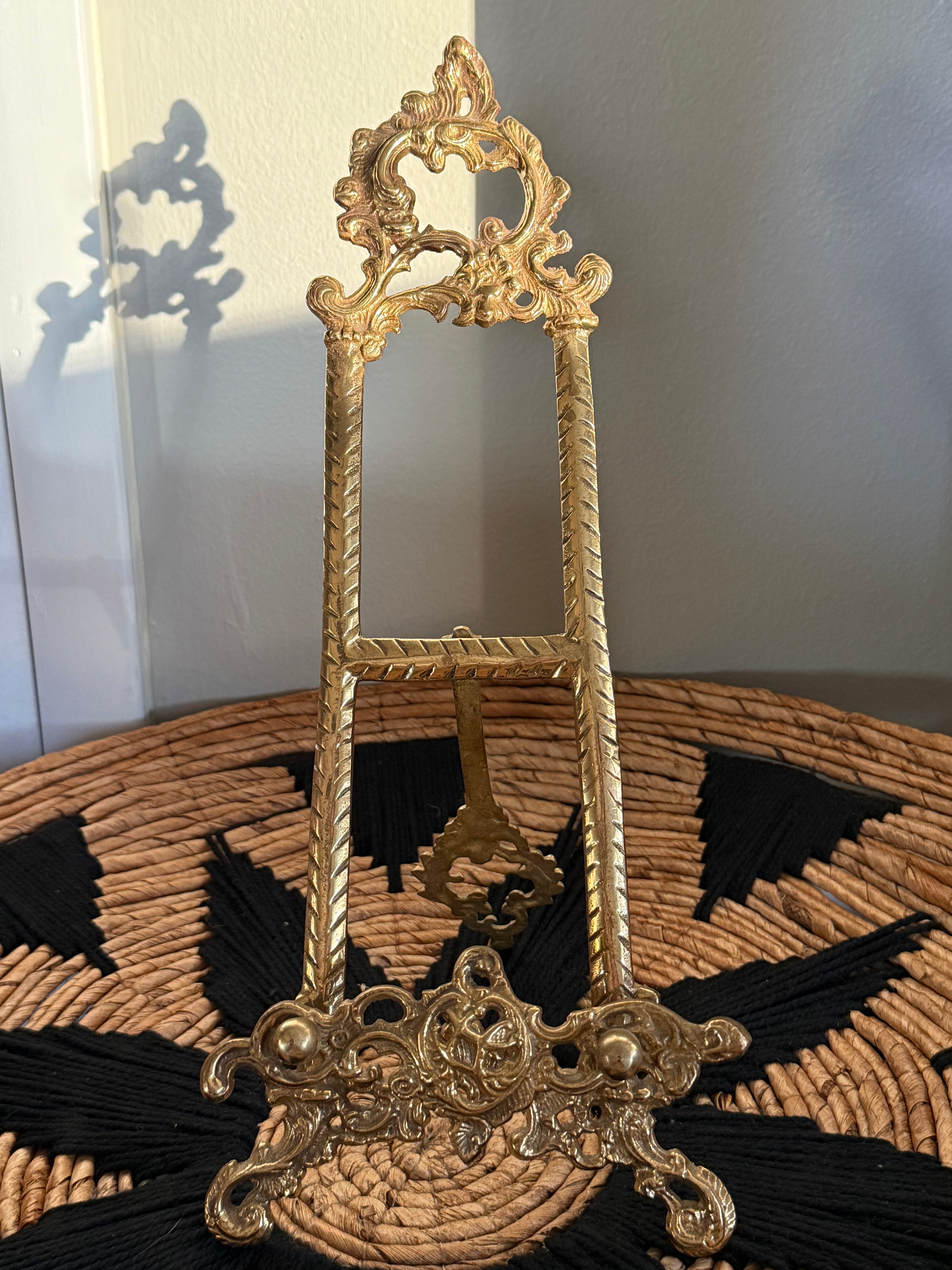 Decorative gold easel on a textured surface with a neutral background