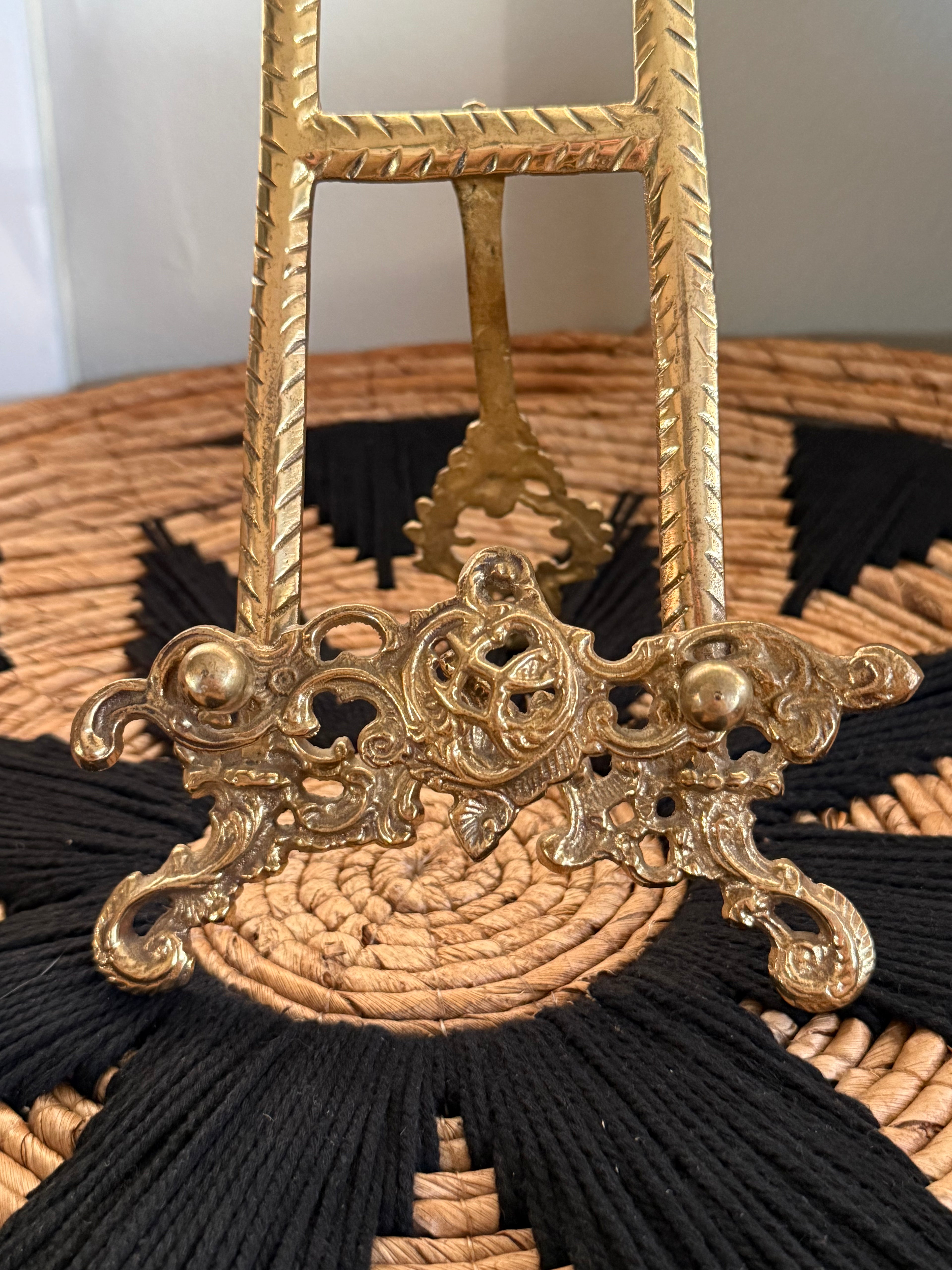 Decorative handbag with gold handle and black tassels on a neutral background