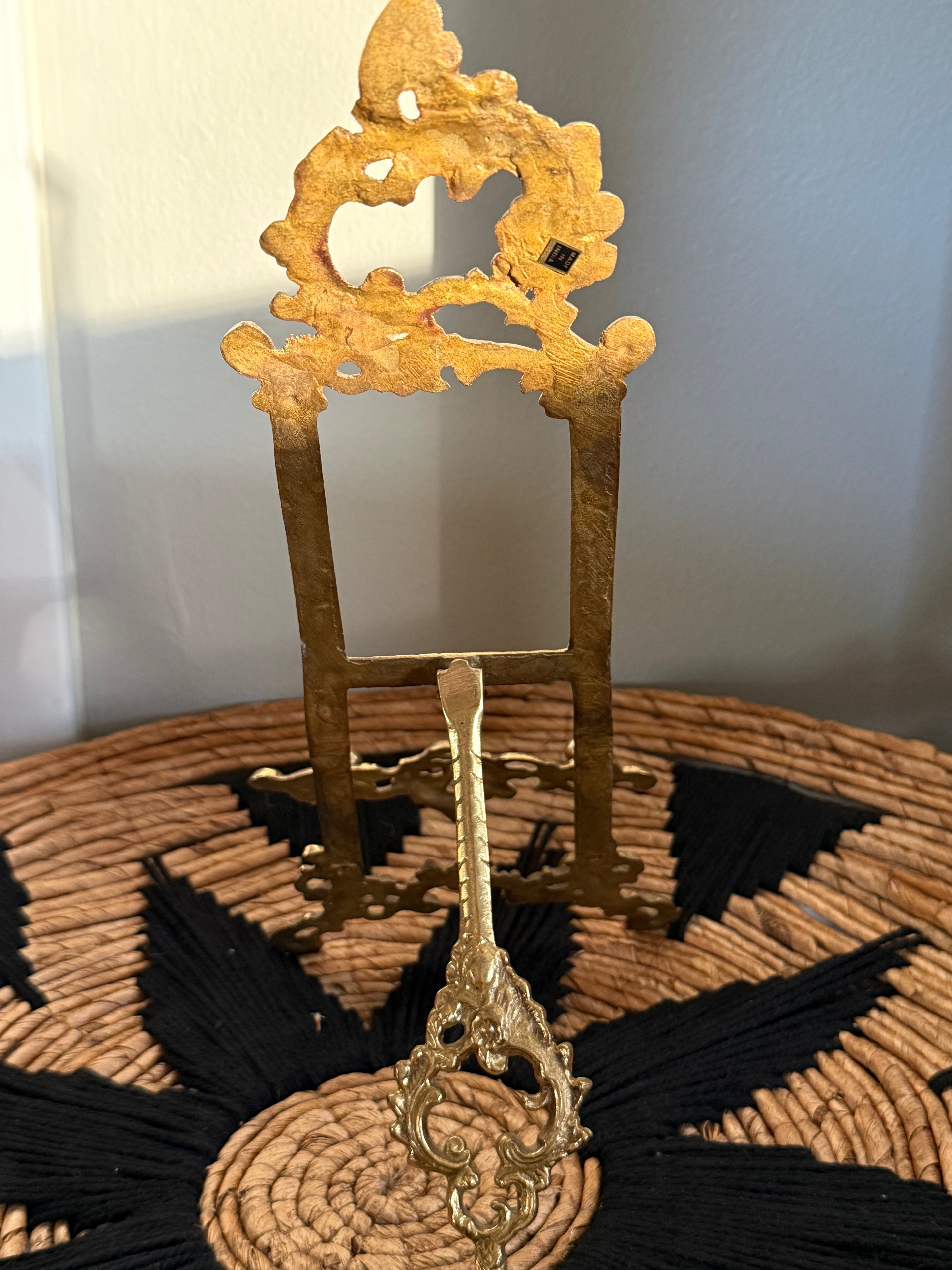Decorative gold stand with intricate design on a textured surface