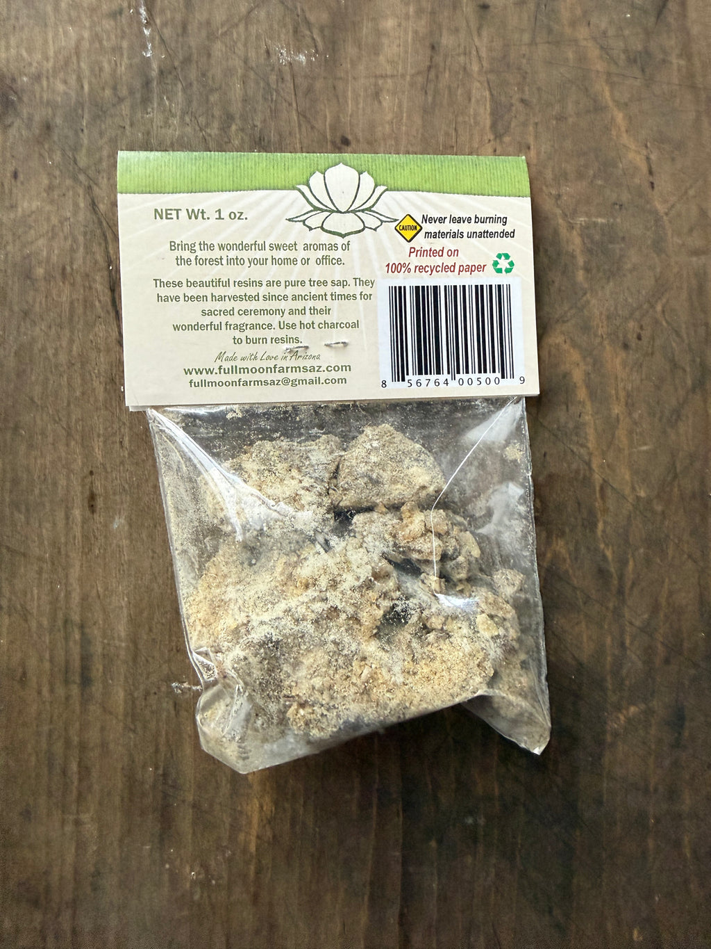 Bag of resin with a label on a wooden surface