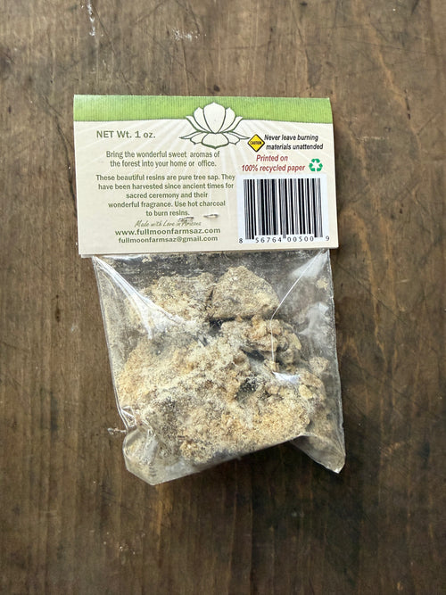 Bag of resin with a label on a wooden surface