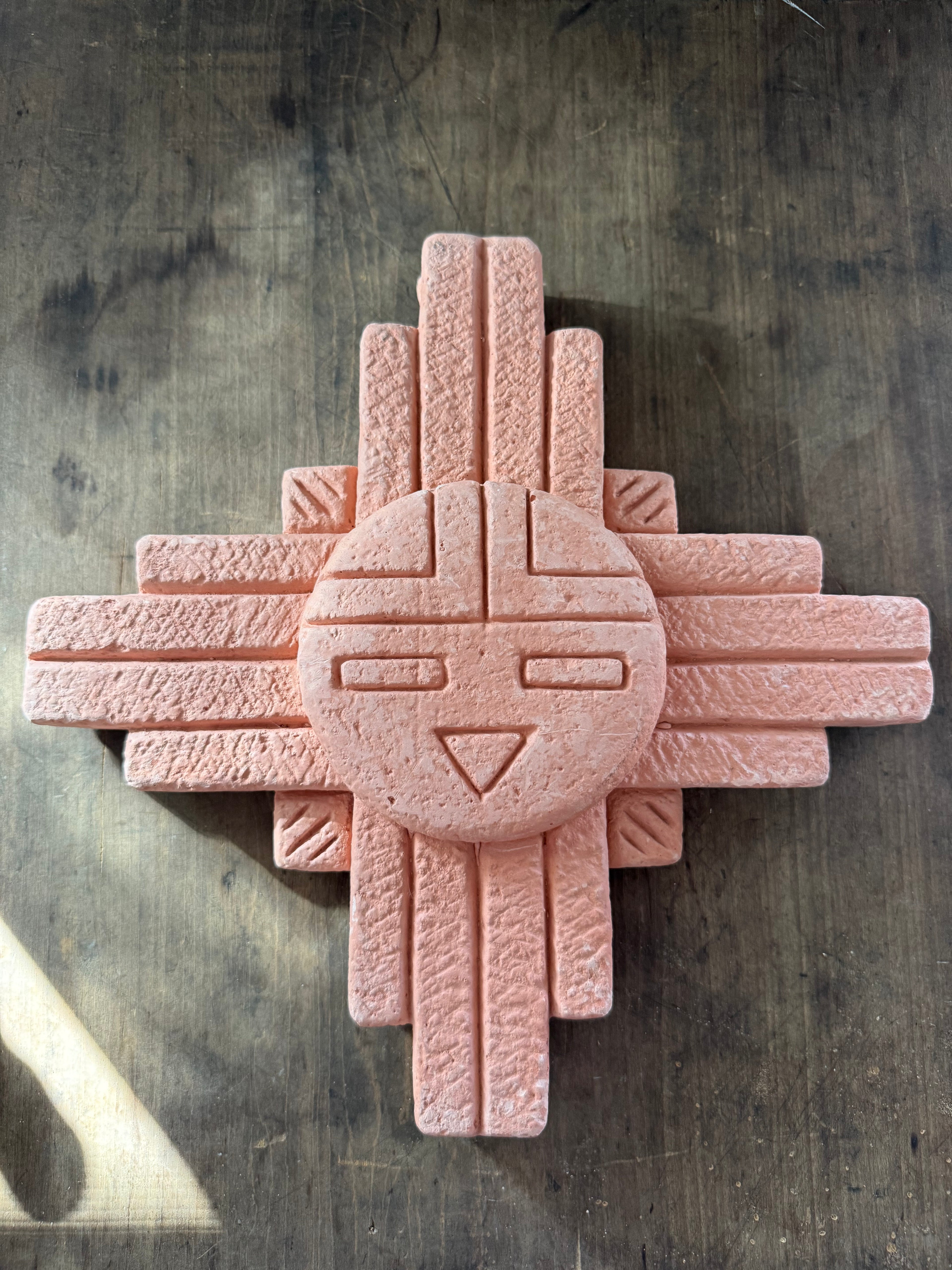 Clay geometric sculpture on a textured surface