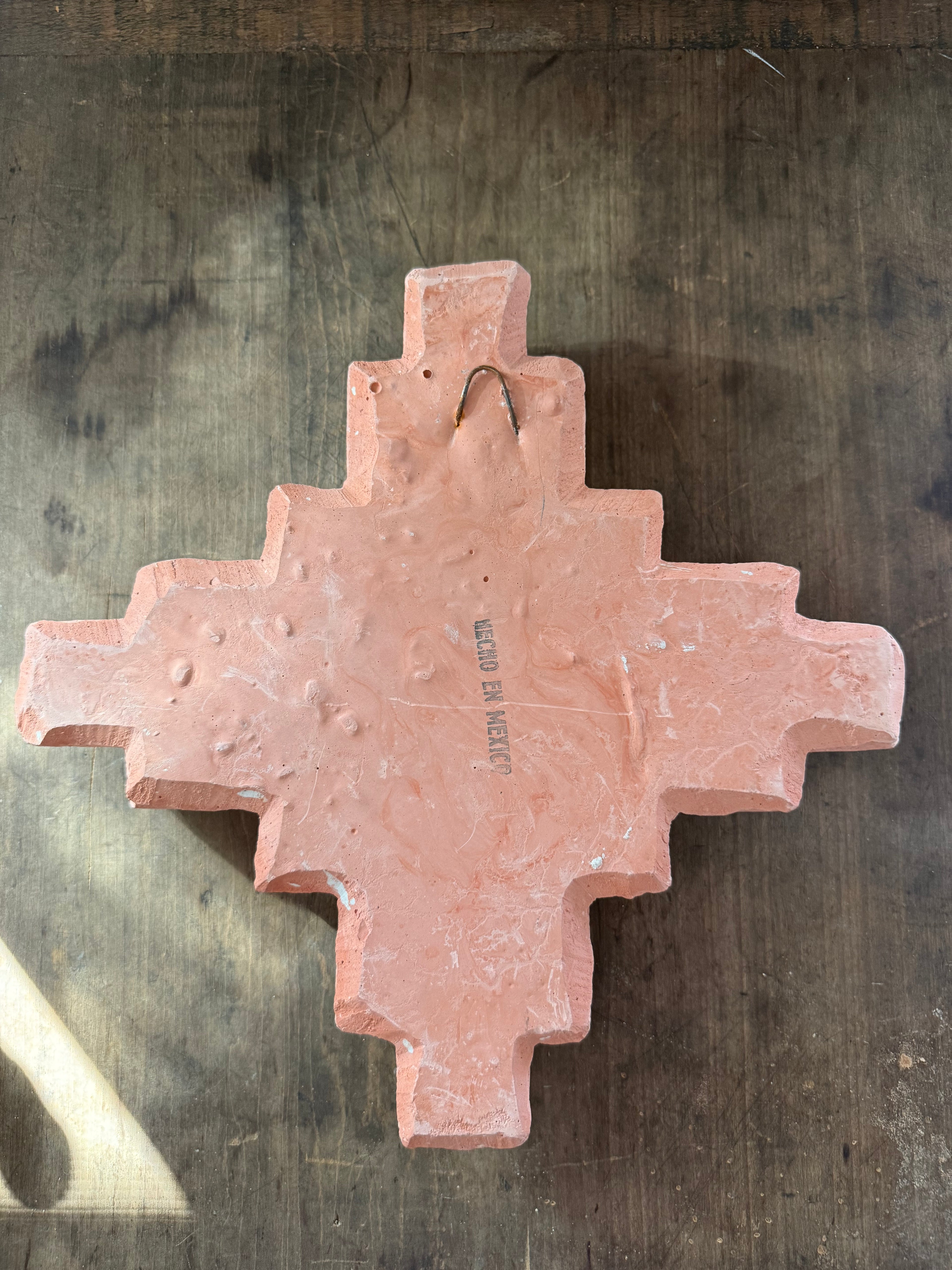 Decorative pink cross on a textured dark surface