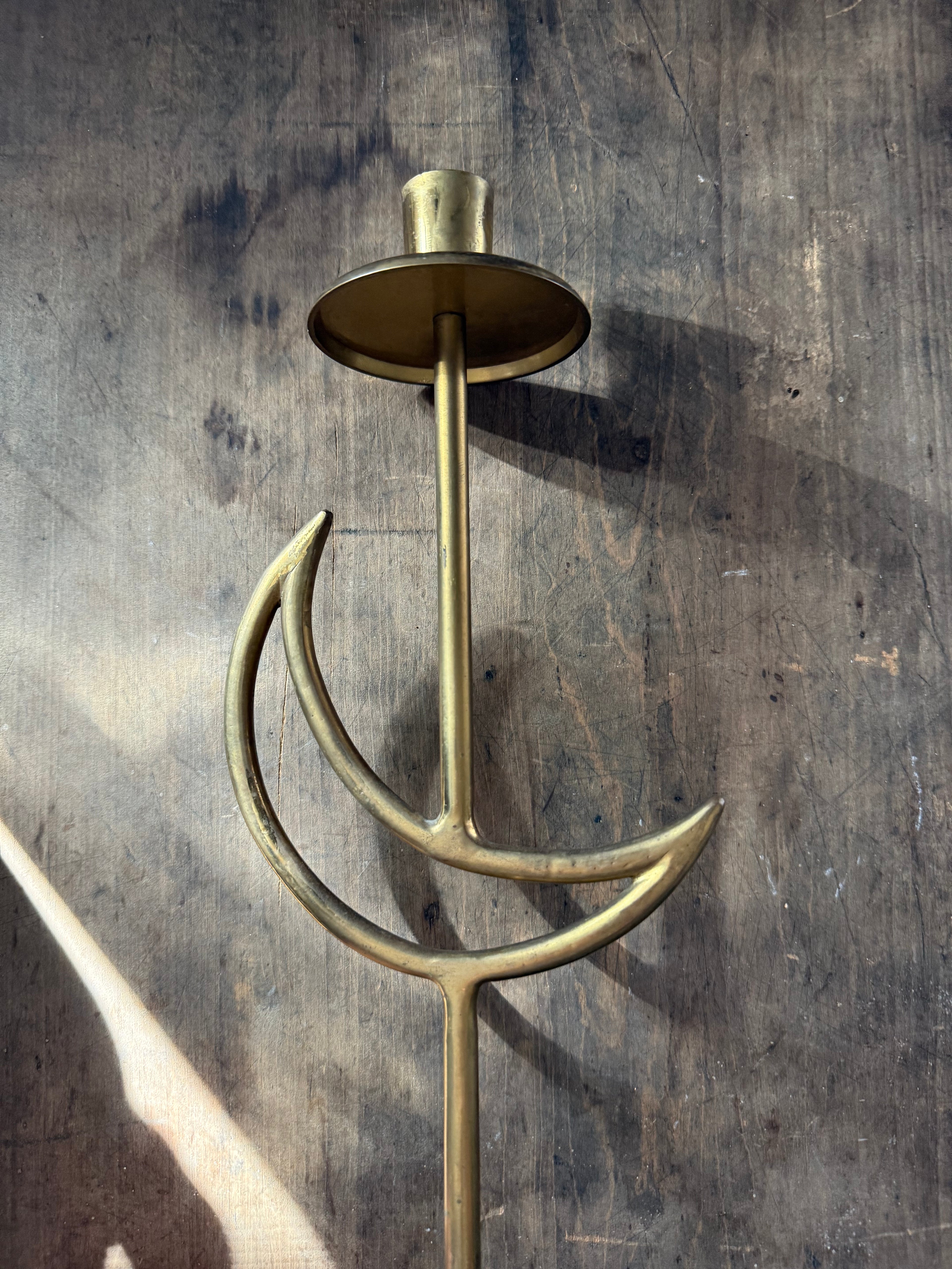 Brass candle holder on a textured wooden background