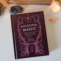 Book titled 'Ancestral Magic' by Frankie Castanea on a surface with crystals and a candle.