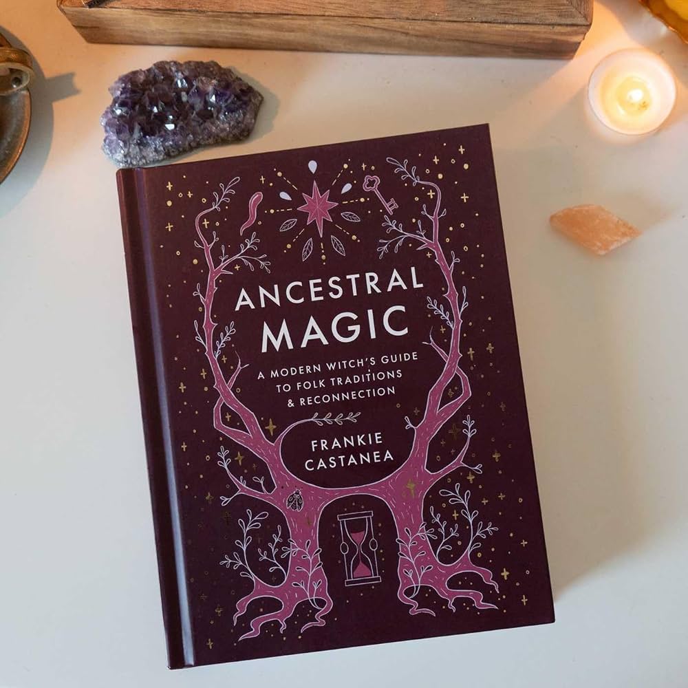 Book titled 'Ancestral Magic' by Frankie Castanea on a surface with crystals and a candle.