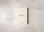 Book titled 'The Becoming Journal' by Bianca Sparacino on a wooden surface