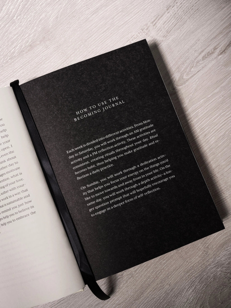 Black journal on a light wooden surface with text on the cover