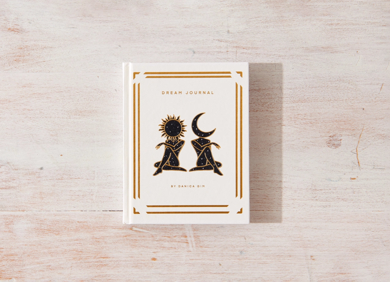 Dream journal with sun and moon design on a wooden surface