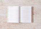 Open notebook with lined pages on a wooden surface