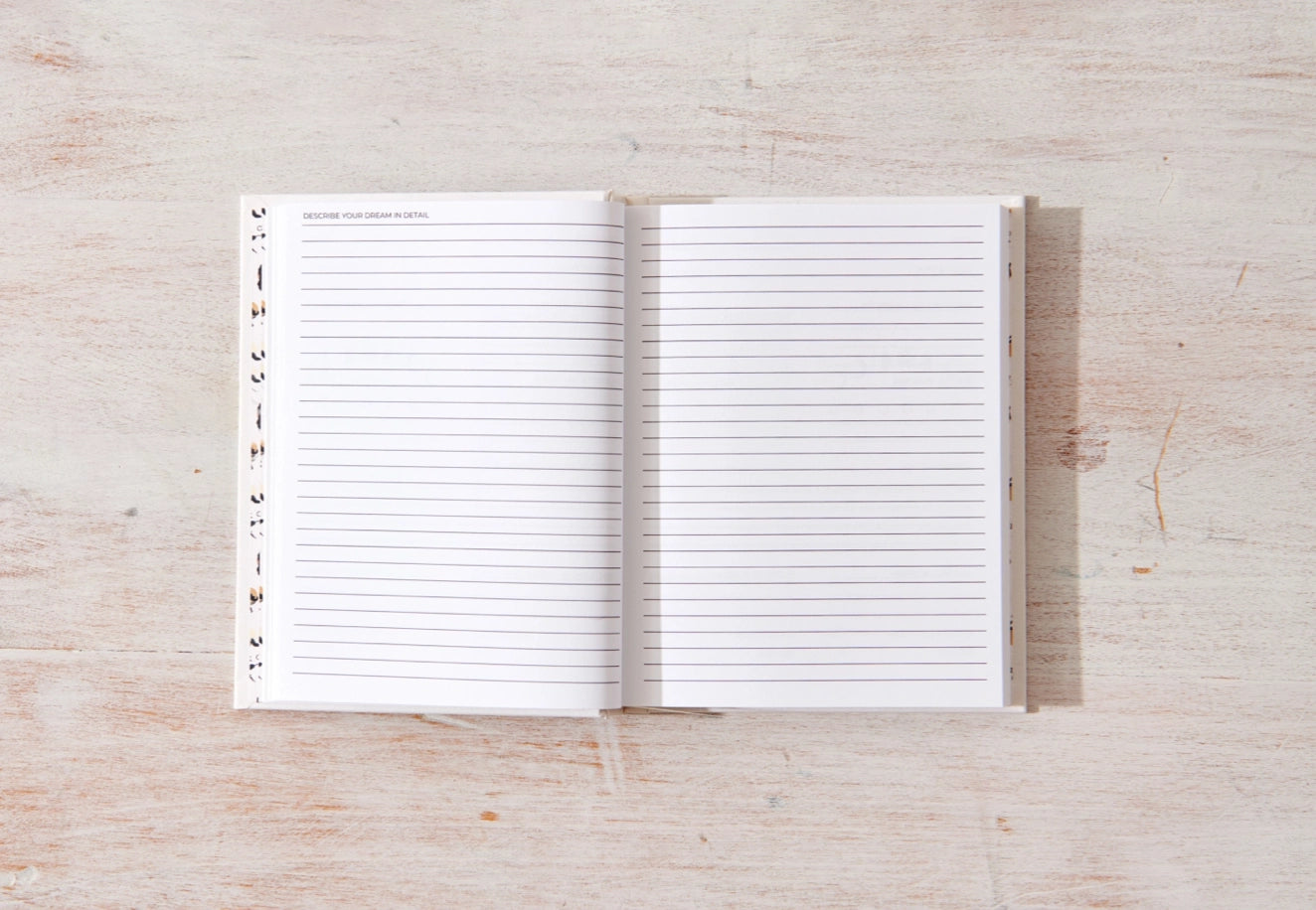 Open notebook with lined pages on a wooden surface