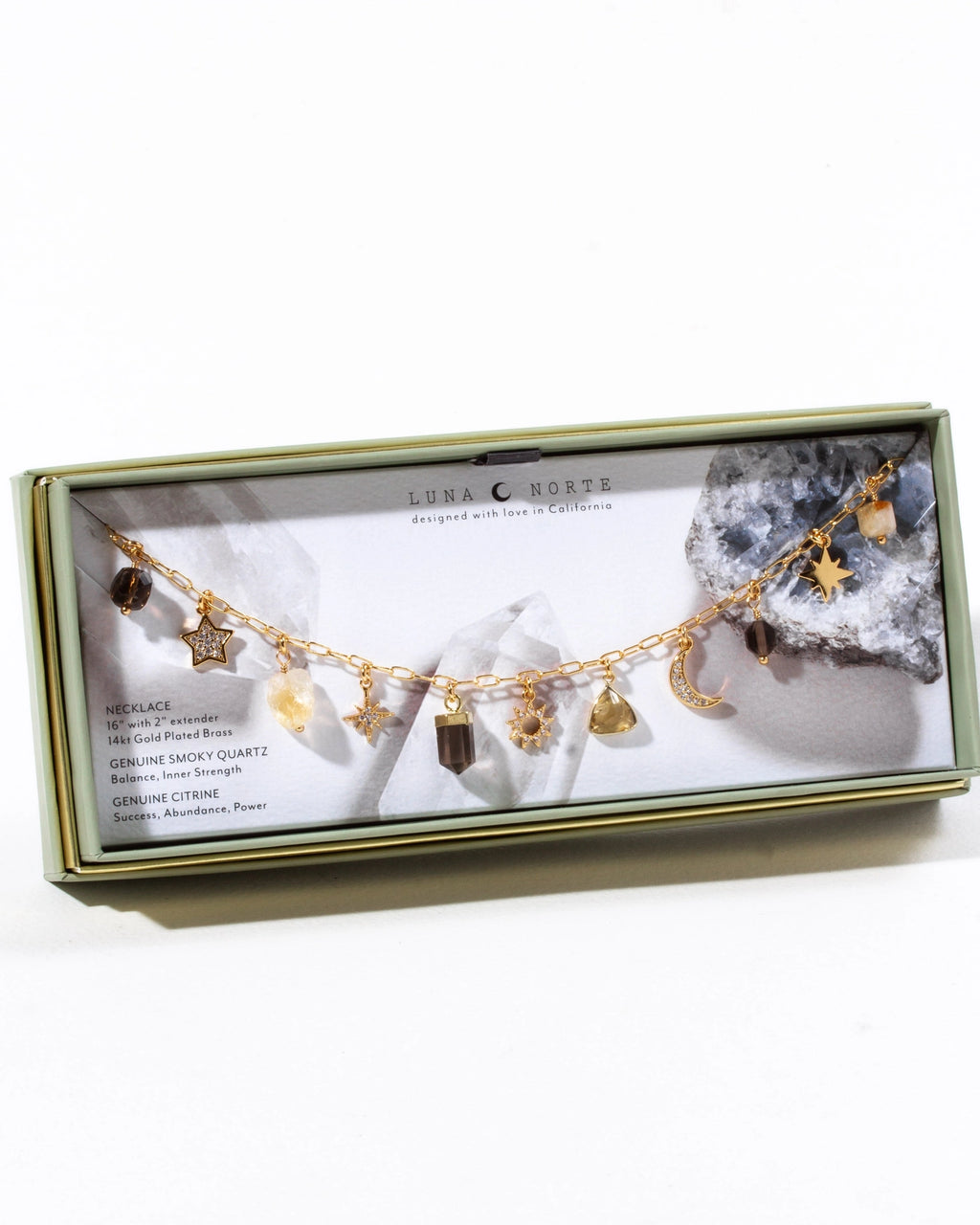 Jewelry box with a gold necklace featuring various charms on a white background