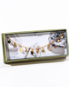 Jewelry box with a gold necklace featuring various charms on a white background
