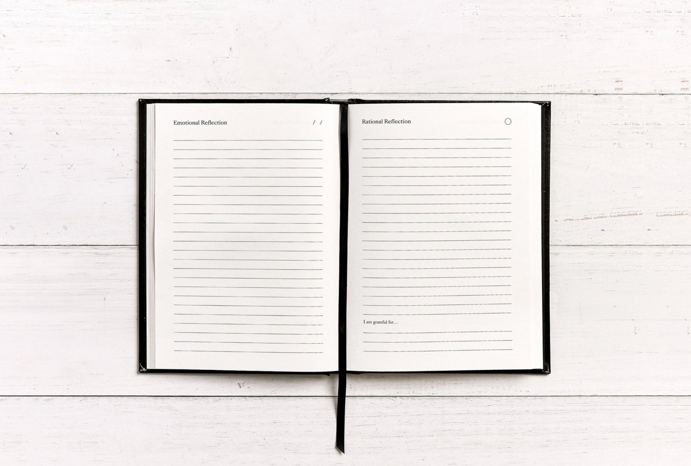 Open notebook with lined pages on a white wooden surface