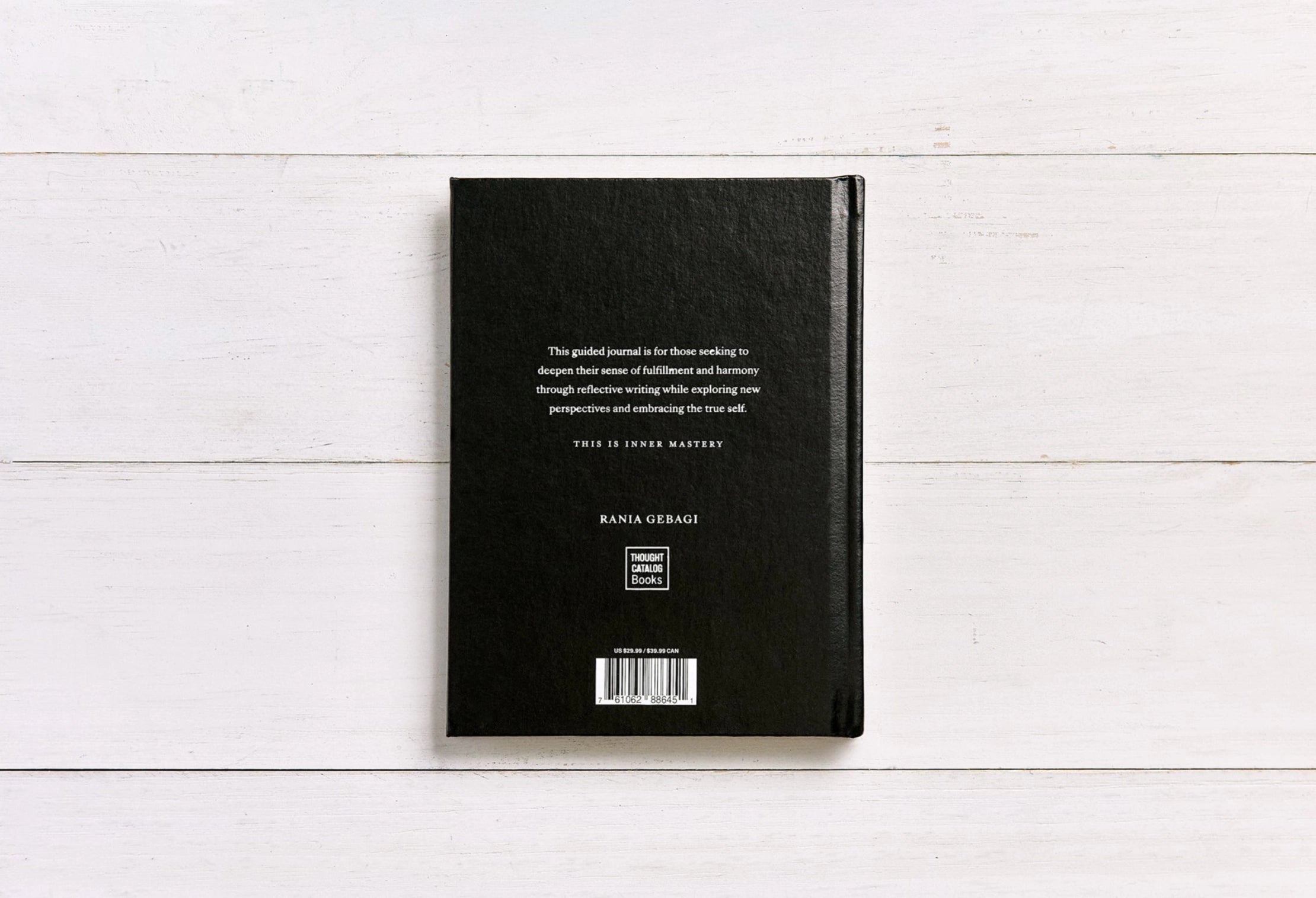 Black notebook with text on a white wooden surface