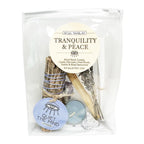 Ritual travel kit labeled 'Tranquility & Peace' with various items including a candle, feather, and crystals.
