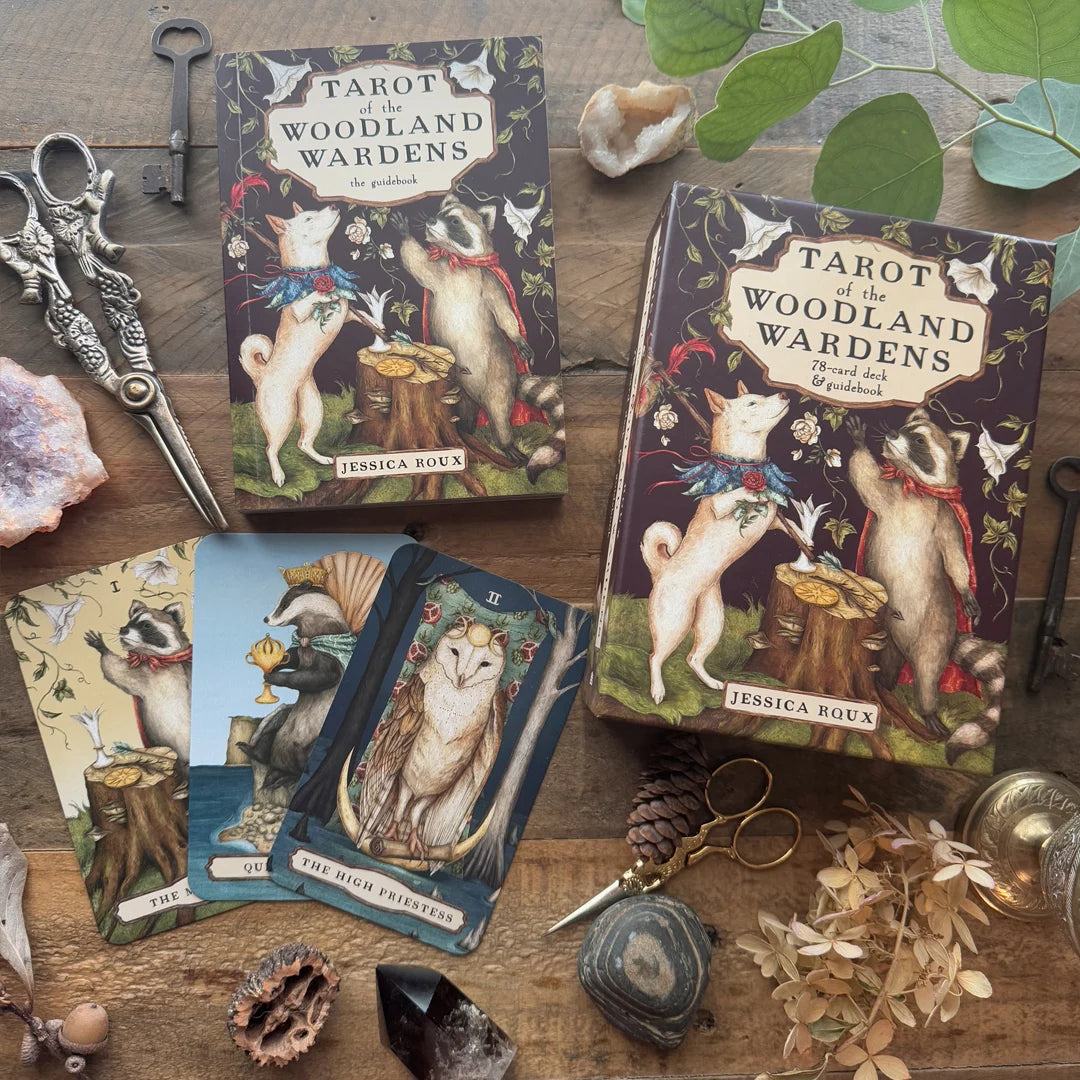 Tarot cards titled 'Tarot of the Woodland Wardens' by Jessica Roux on a wooden surface with nature-themed decor.